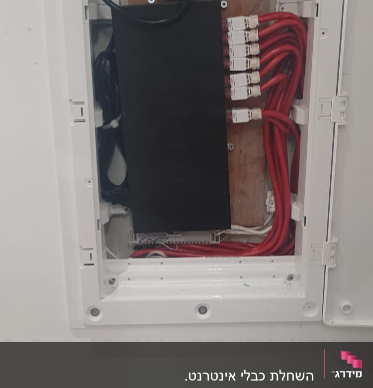 ארון תקשורת עם כבלים אדומים ושקע חשמל